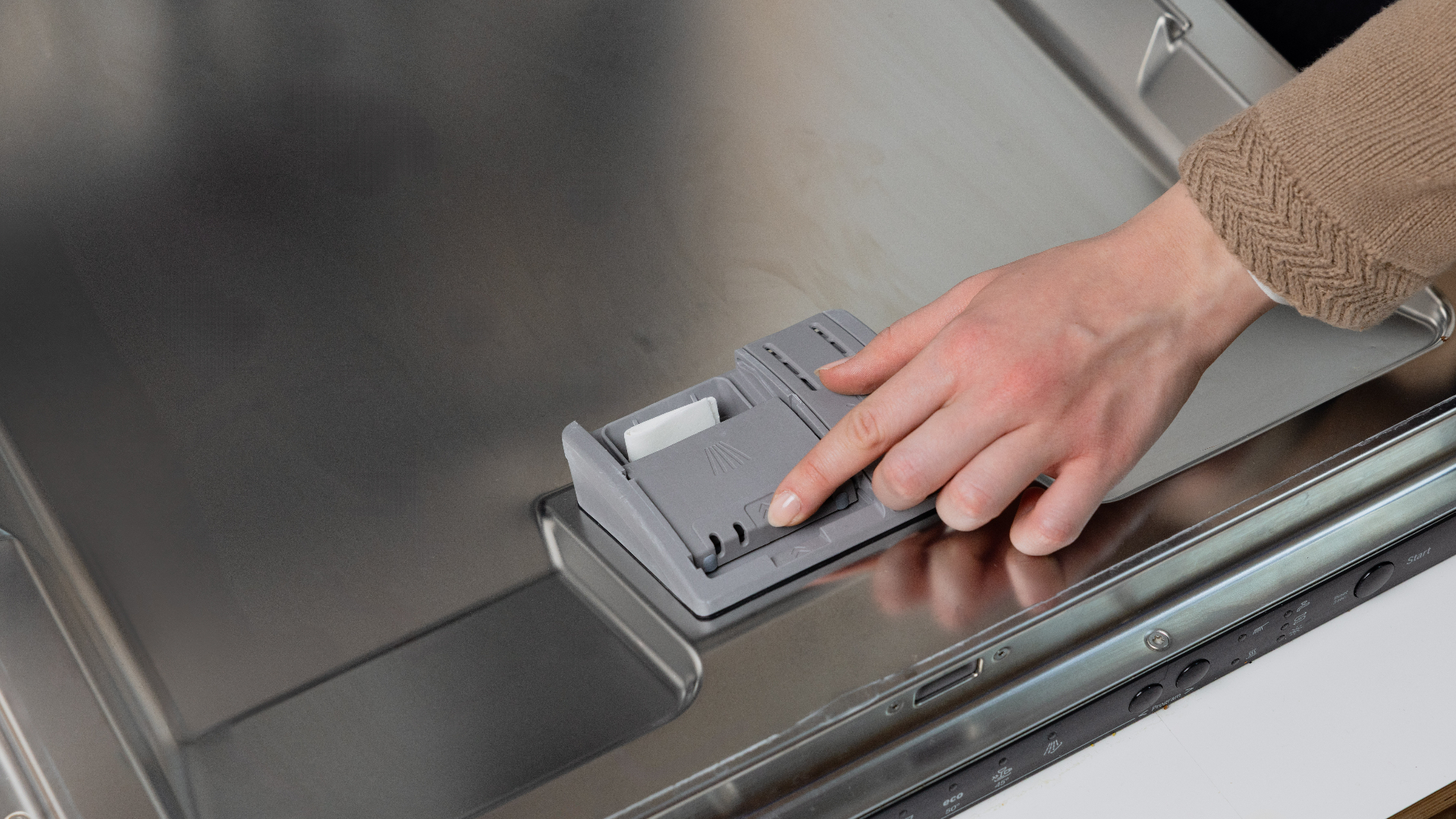 Placing a Dip dishwasher sheet into the dishwasher dispenser